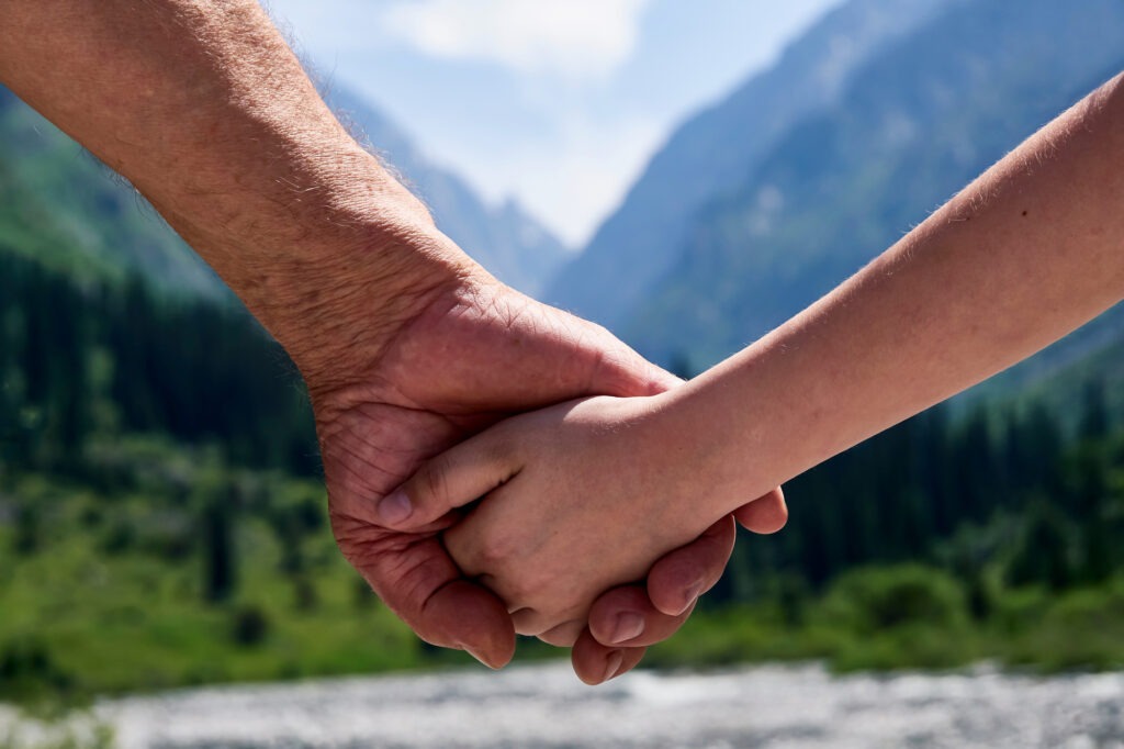 Closeup photo of a child the hand of his elderly grandfather